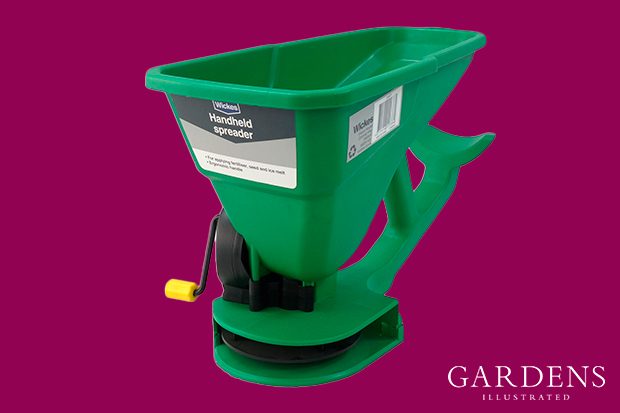 Wickes Hand Held Lawn Spreader on a pink background