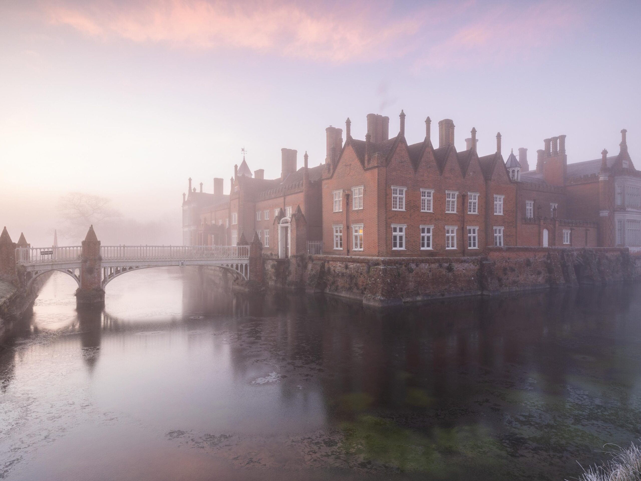 Stately home in mist surounded by moat