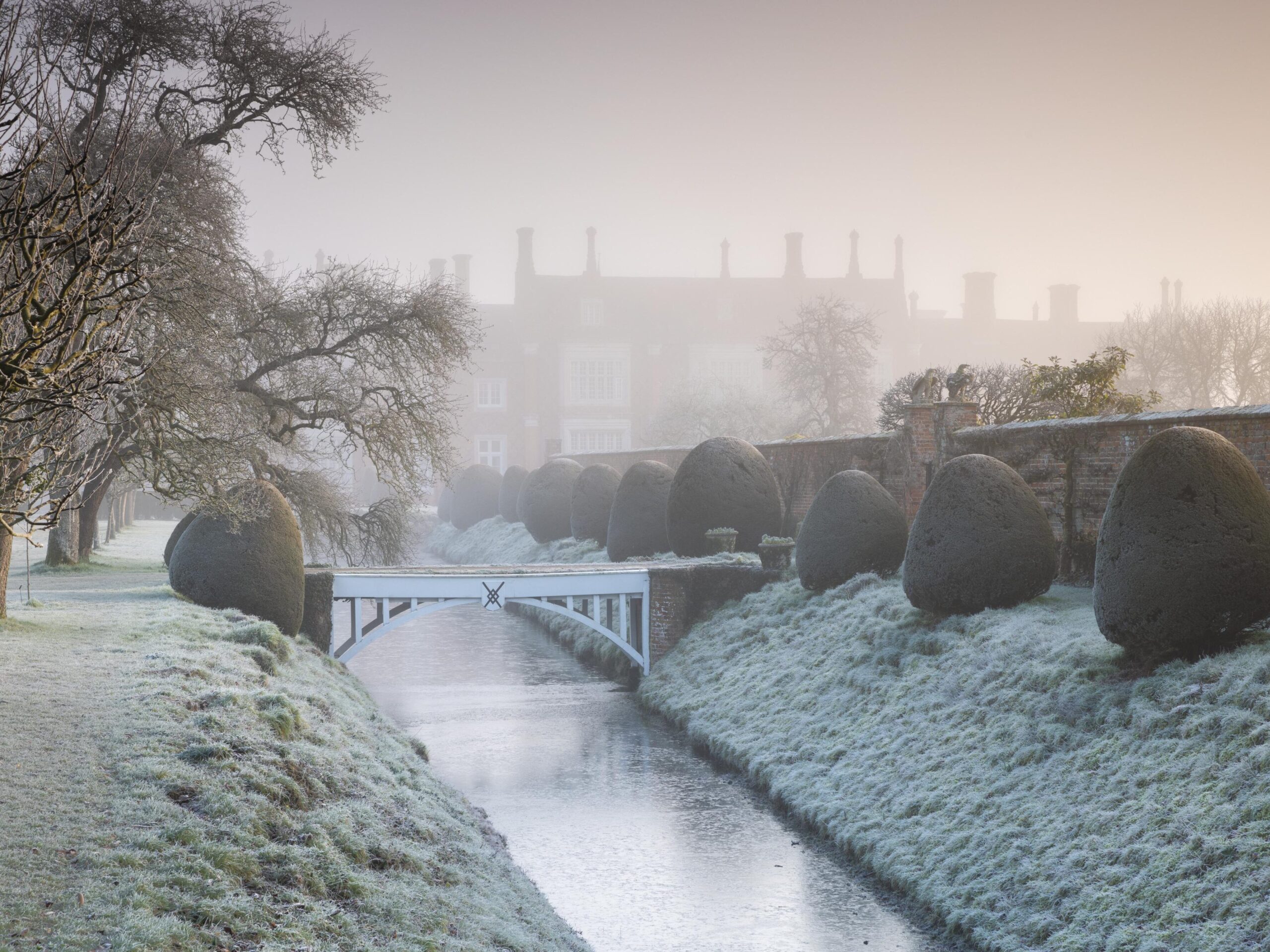 Ancient bridge over steam and house