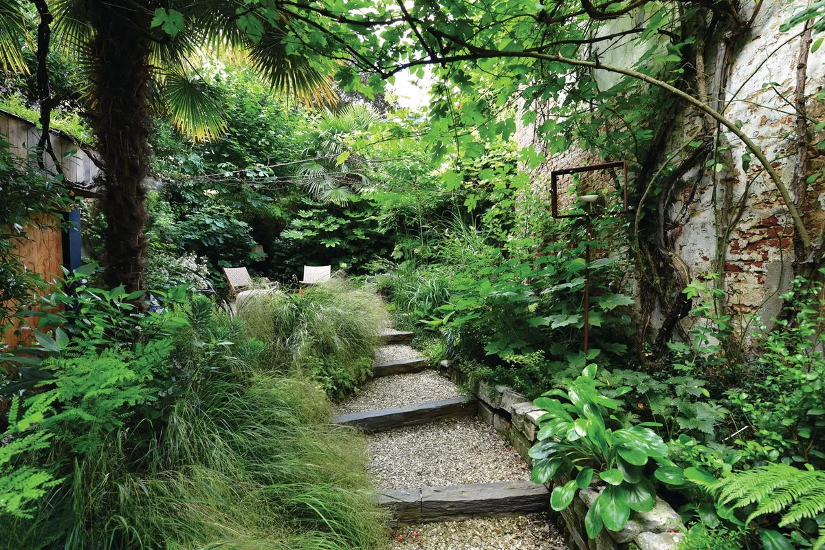 Erik Funnerman garden in Utrecht Green lush garden with steps and chairs
