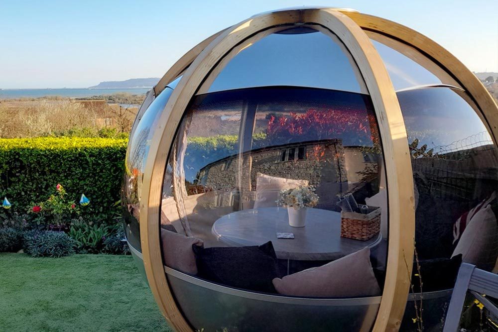 Ornate Garden Luxury Rotating Seater Garden Pod in a garden