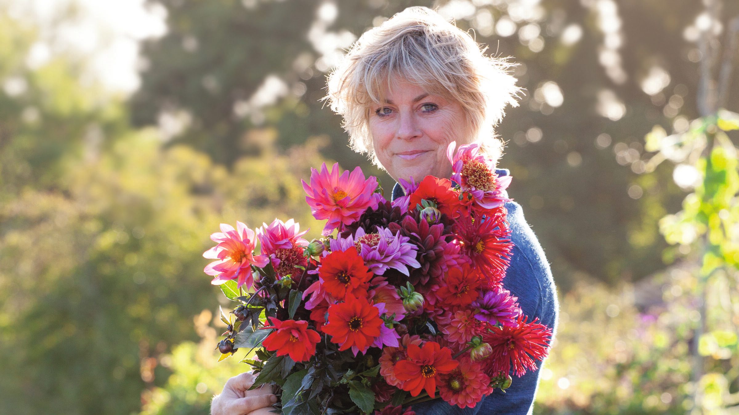 Sarah Raven carrying a bunch of dahlias