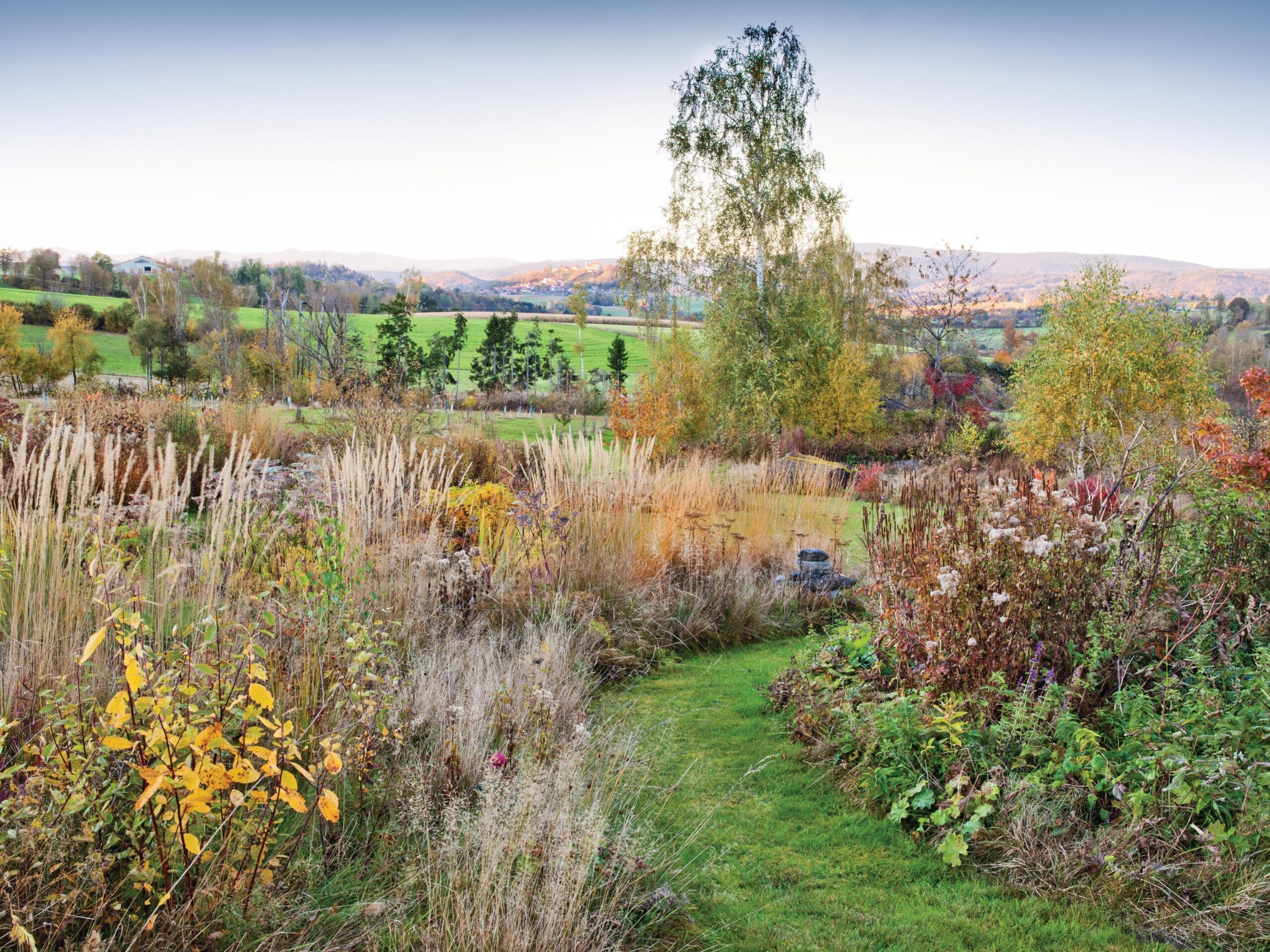 Garden in bloom surrounded by countryside by Karin Winkler