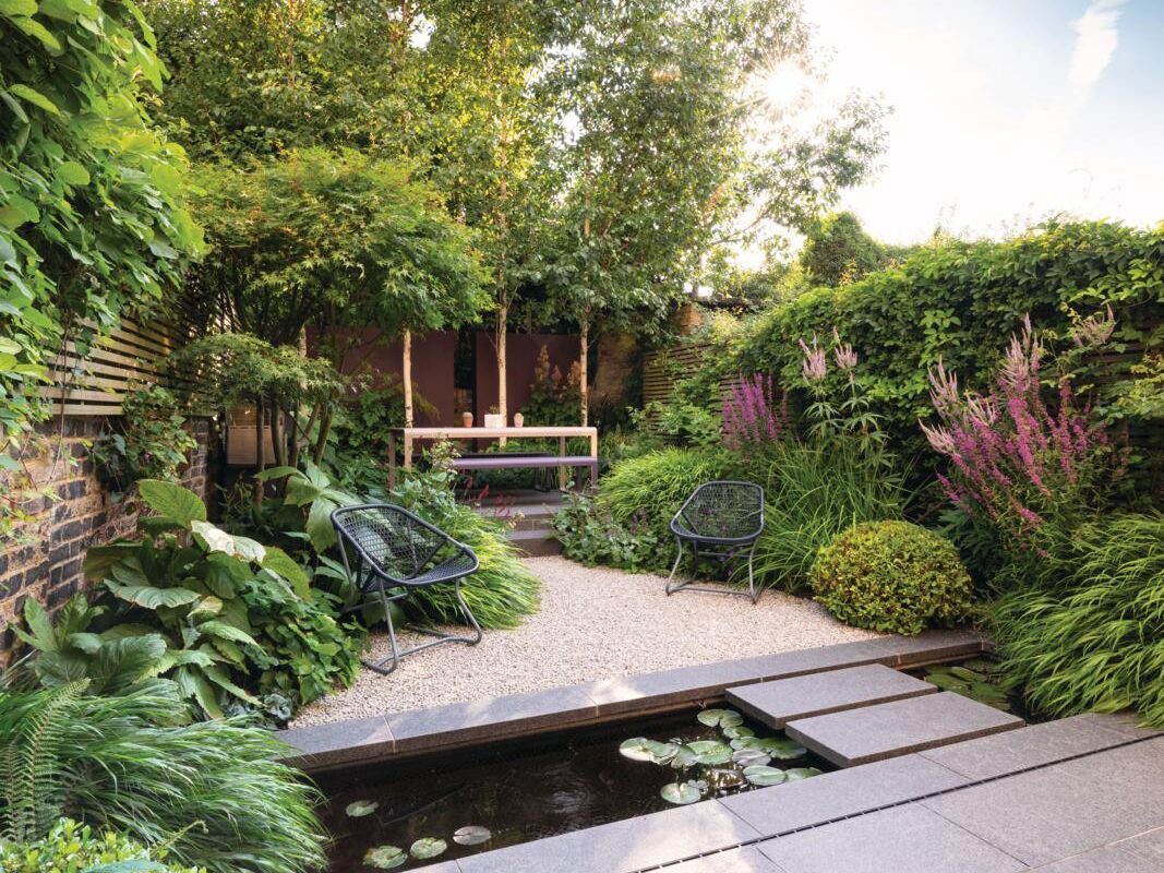 A garden with a path and water feature designed by John Davies