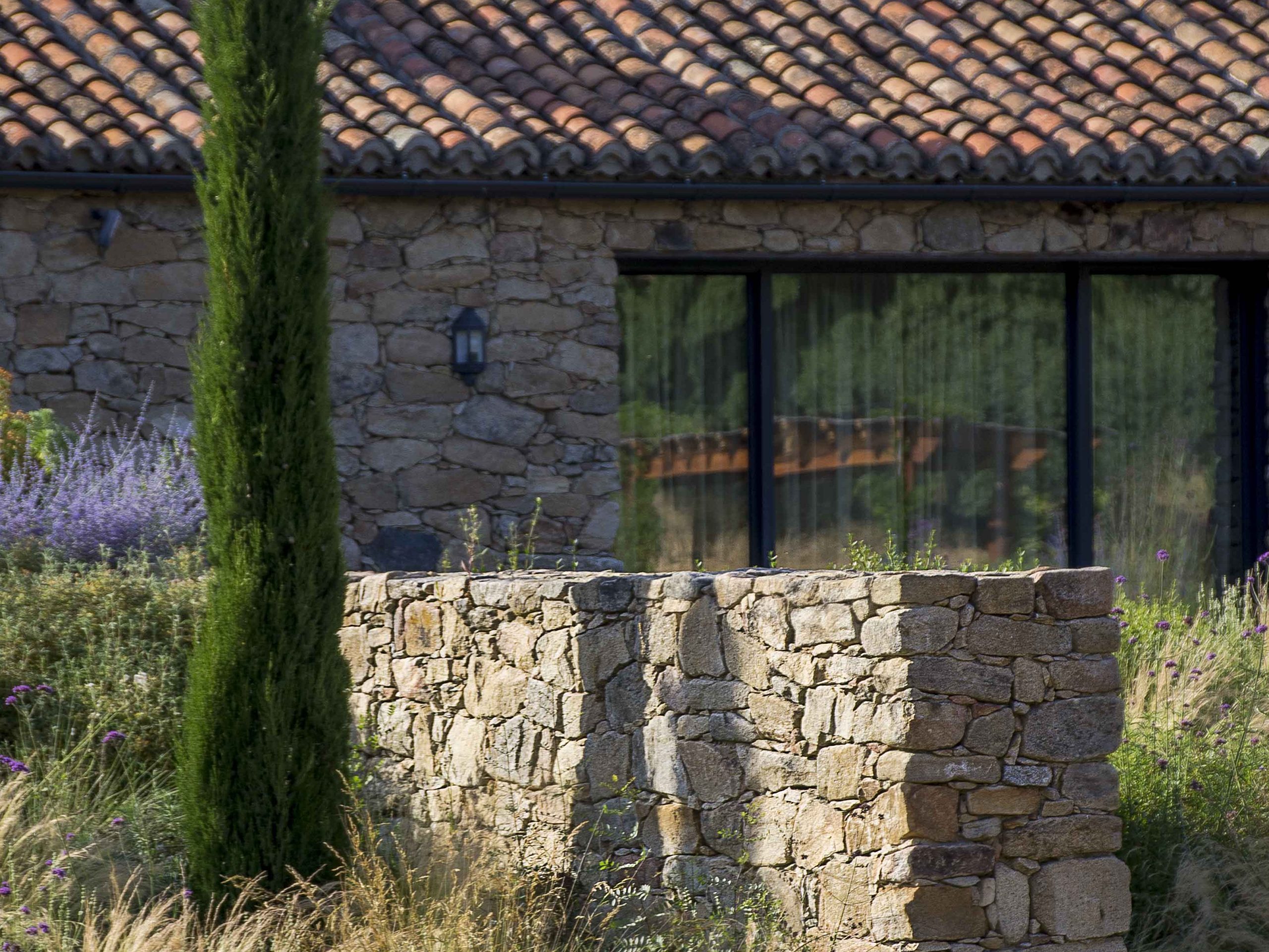 In this garden by Locus Landscape, garden walls reflect the stone of the house.