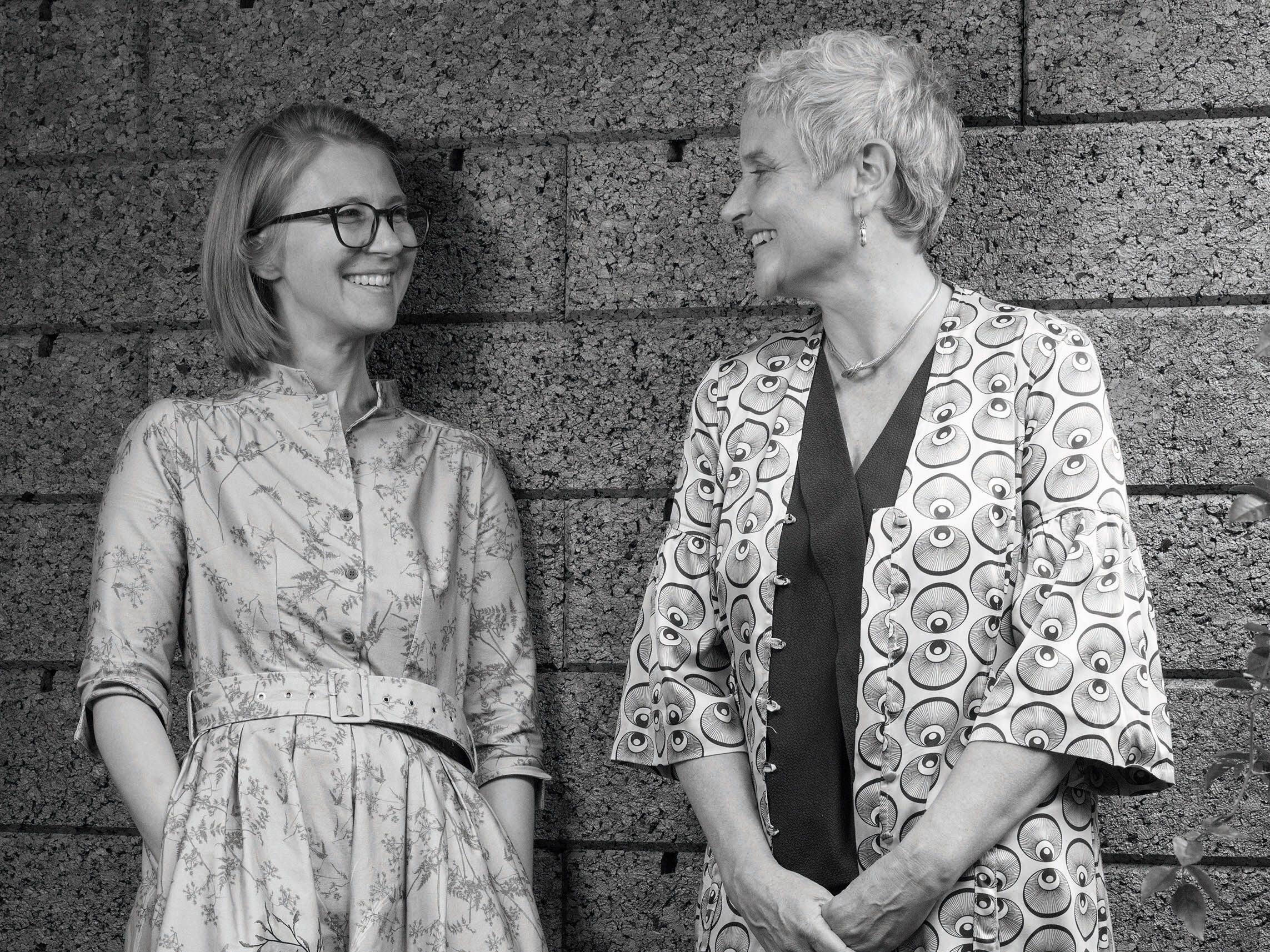 Two women stood against a wall