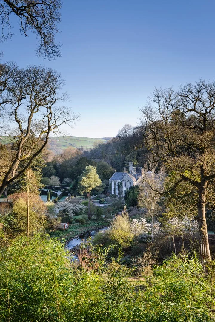 Gresgarth Hall sits at the mouth of a wooded valley, with the brook Artle Beck drawing a sweeping curve as it rushes past the house. Dark yew hedges stamp formality near the house and echo the stone walls etched on the hills beyond. Gresgarth Hall sits at the mouth of a wooded valley, with the brook Artle Beck drawing a sweeping curve as it rushes past the house. Dark yew hedges stamp formality near the house and echo the stone walls etched on the hills beyond.
